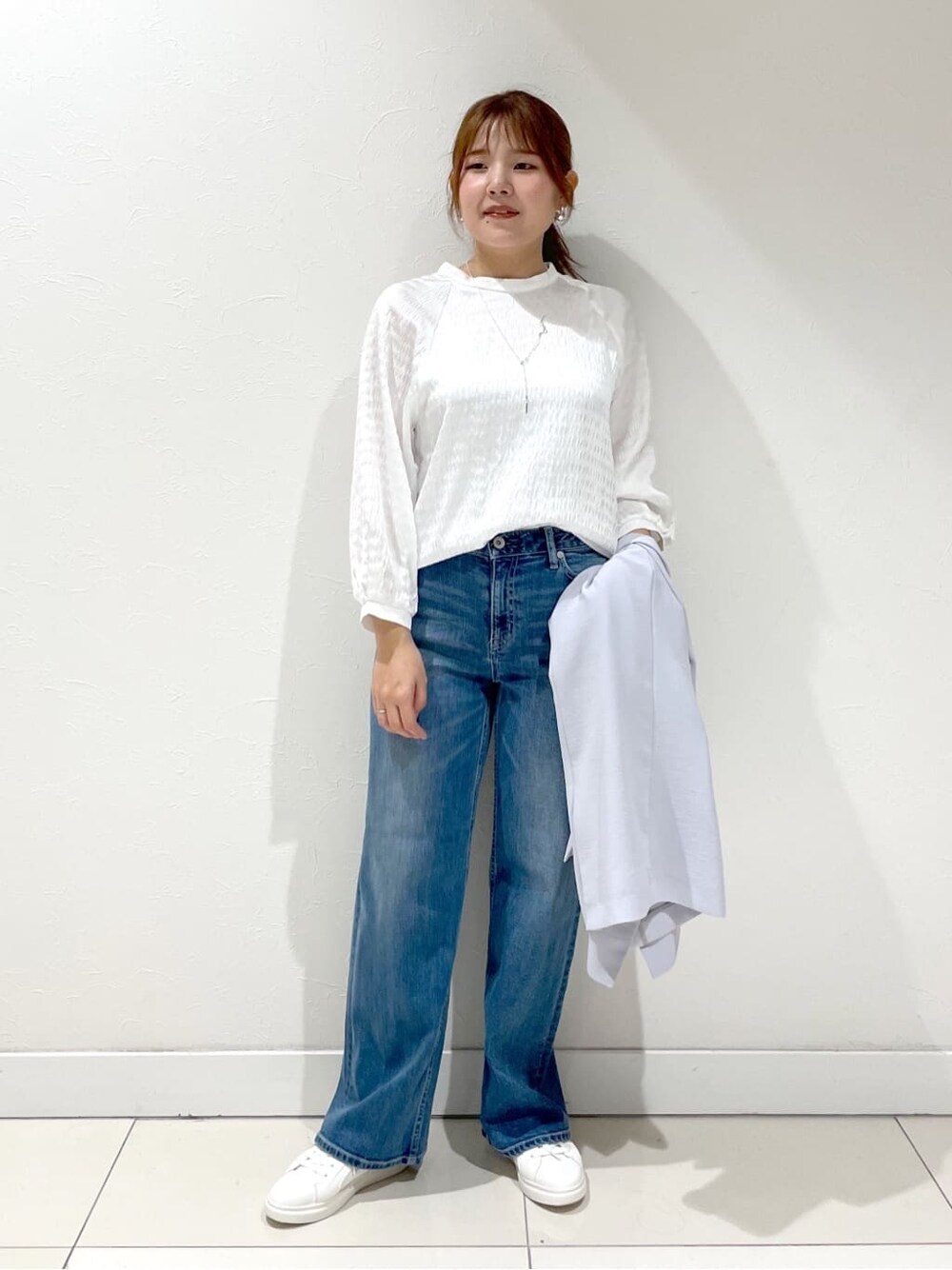 グレー系のスーツジャケット、ホワイト系のシャツ/ブラウス、ブルー系のデニムパンツを着用したレディースの夏コーディネートの1枚目の写真
