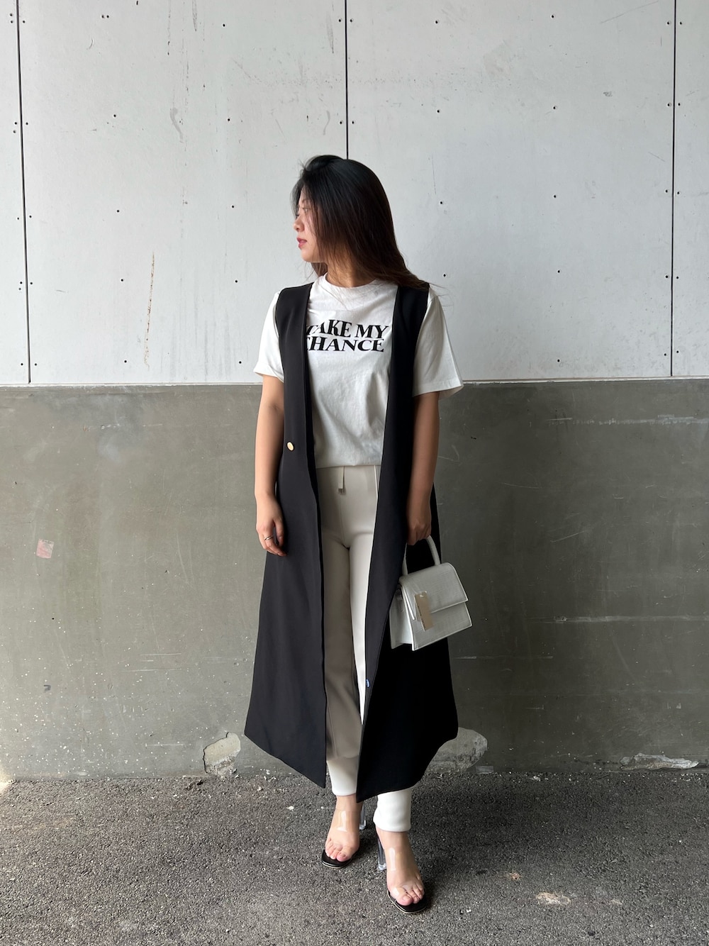 ホワイト系のTシャツ/カットソー、ブラック系のサンダル、グリーン系のジャンパースカートを着用したレディースの春コーディネートの2枚目の写真