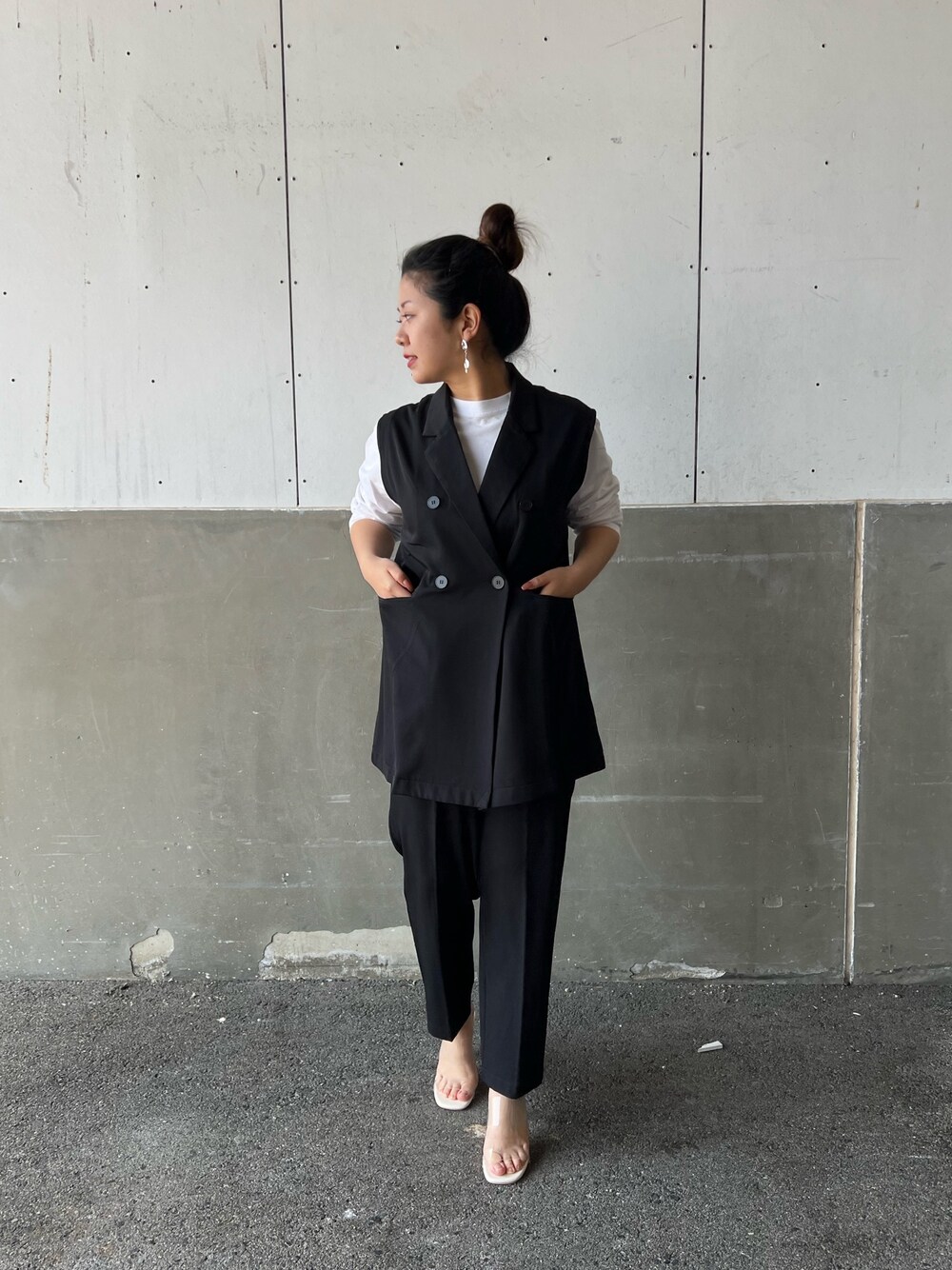 グリーン系のセットアップ、ホワイト系のサンダルを着用したレディースの春コーディネートの2枚目の写真