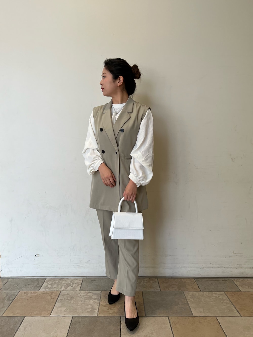 ホワイト系のショルダーバッグ、グリーン系のセットアップ、ホワイト系のシャツ/ブラウスを着用したレディースの春コーディネートの2枚目の写真