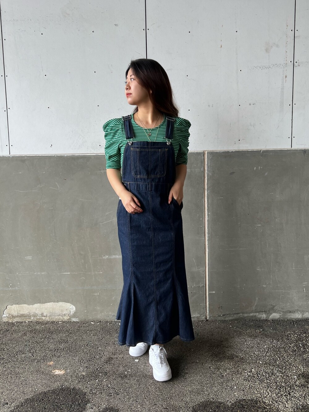 グリーン系のTシャツ/カットソー、ブルー系のワンピース、ホワイト系のスニーカーを着用したレディースの春コーディネートの2枚目の写真