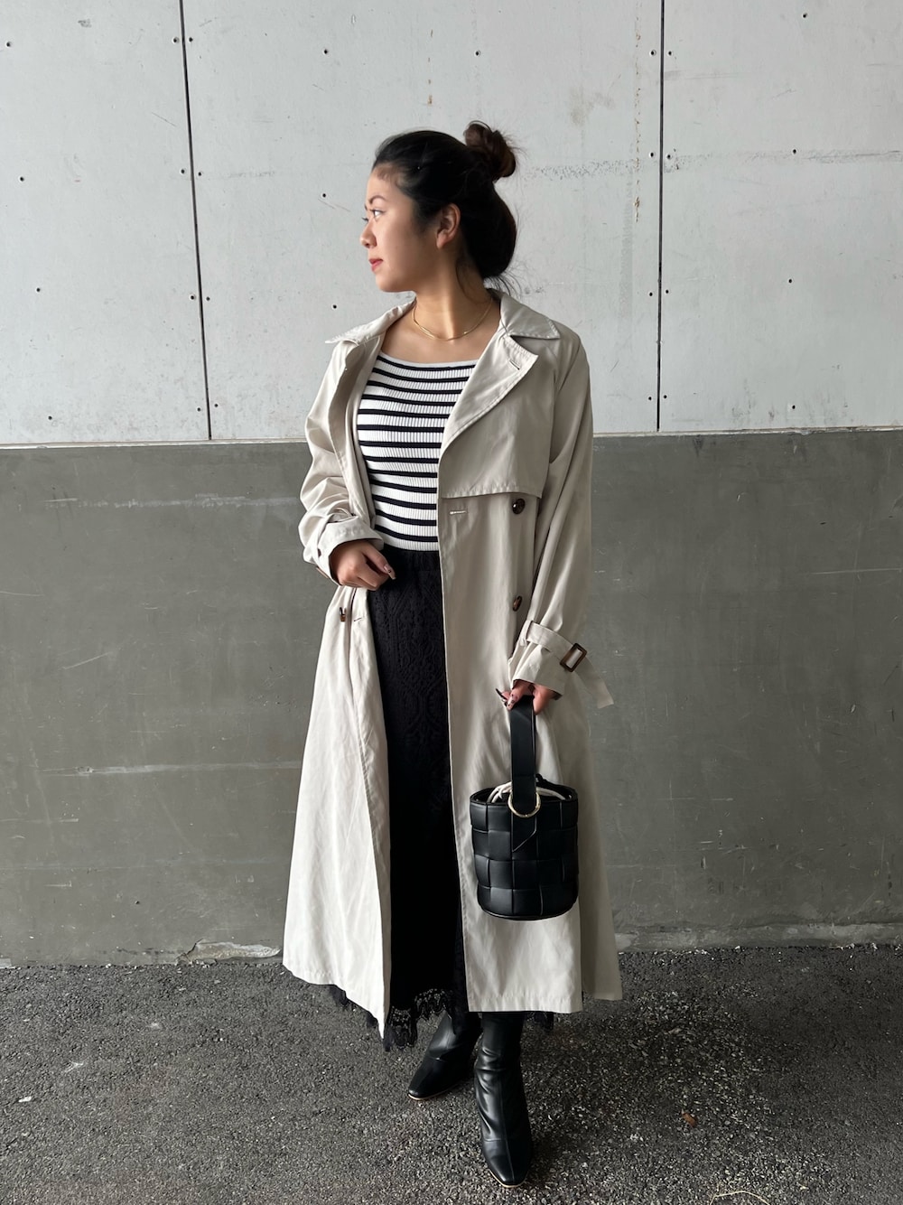 ブラック系のショルダーバッグ、ブラック系のスカート、ホワイト系のニット/セーターを着用したレディースの冬コーディネートの2枚目の写真