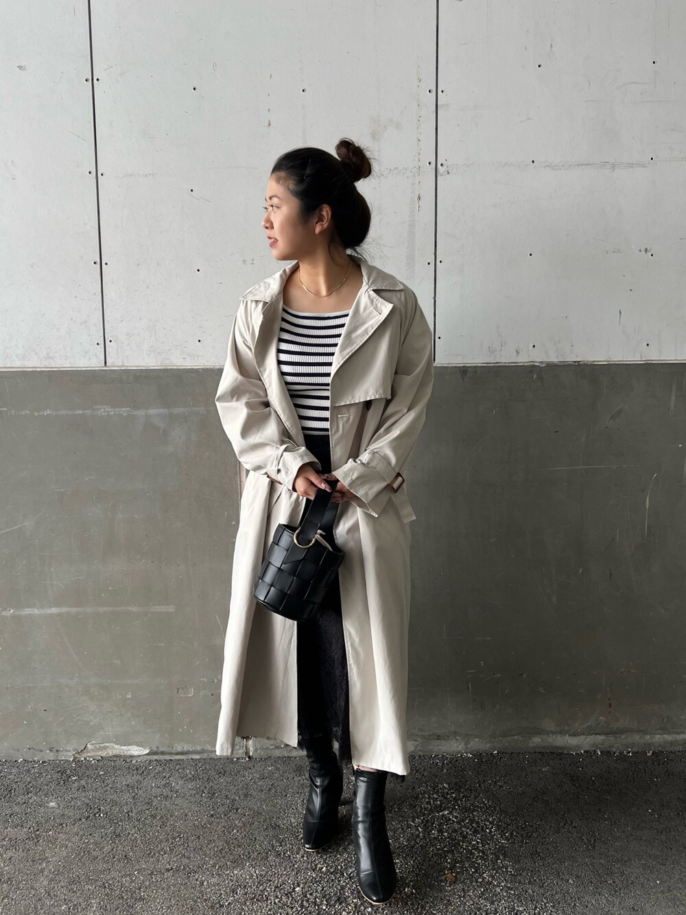 ブラック系のショルダーバッグ、ブラック系のスカート、ホワイト系のニット/セーターを着用したレディースの冬コーディネートの3枚目の写真