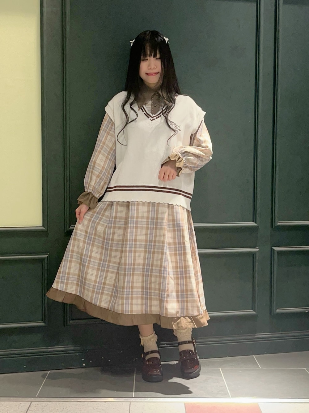 ホワイト系のニット/セーター、ベージュ系のワンピース、ブラウン系のローファーを着用したレディースの冬コーディネートの1枚目の写真