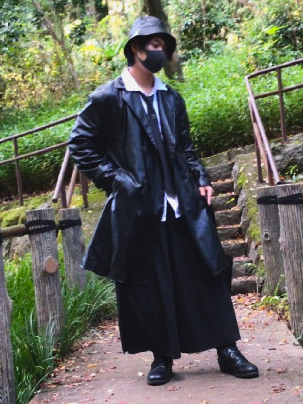 ブラック系のチェスターコート、ブラック系のその他パンツ、ブラック系のネクタイを着用したメンズの秋コーディネートの1枚目の写真