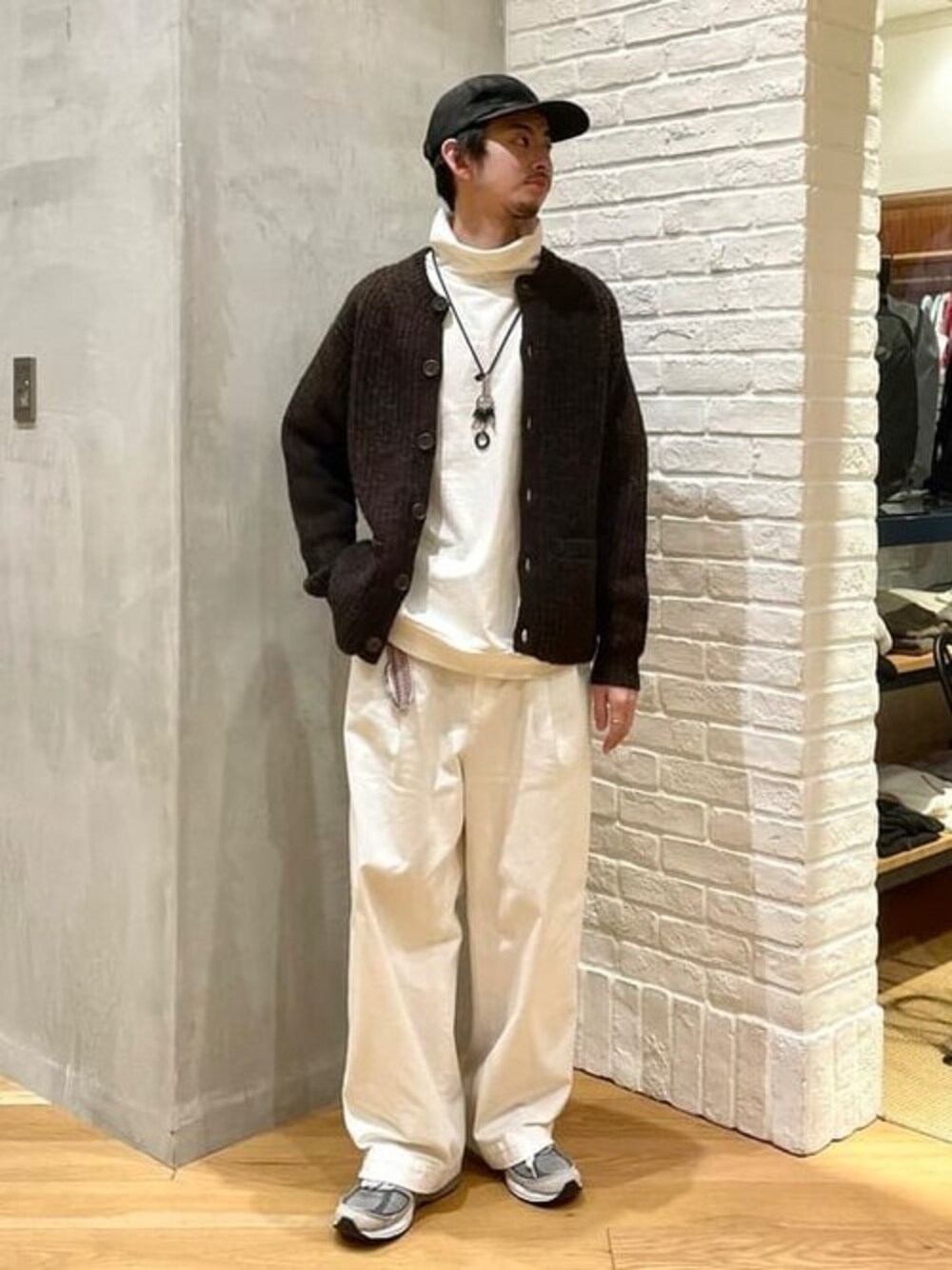 ブラウン系のカーディガン/ボレロ、ホワイト系のTシャツ/カットソー、ホワイト系のチノパンツを着用したメンズの冬コーディネートの1枚目の写真