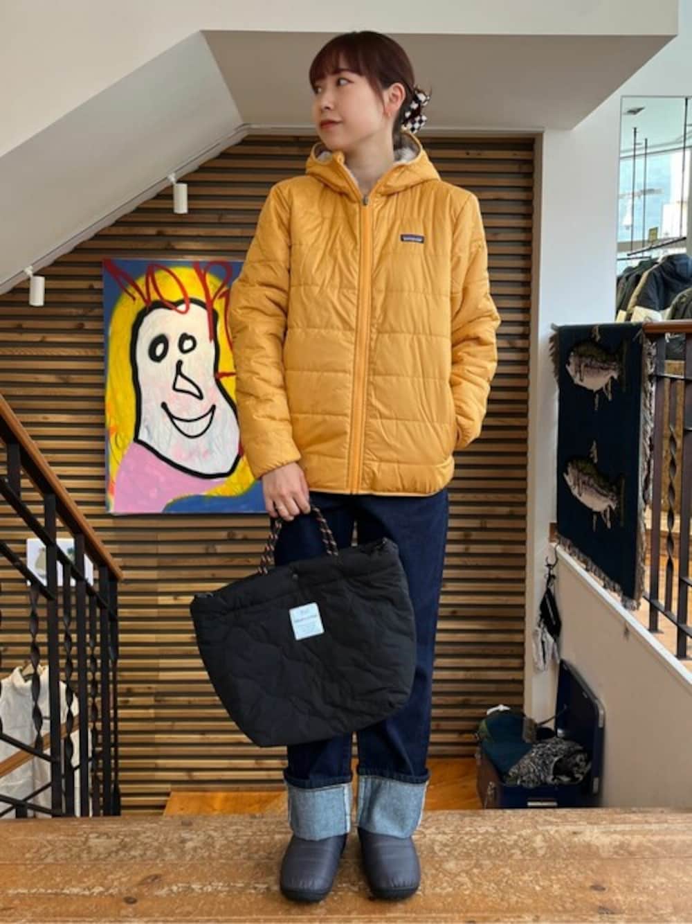 ブラック系のトートバッグ、ブルー系のデニムパンツ、グレー系のサンダルを着用したレディースの冬コーディネートの1枚目の写真