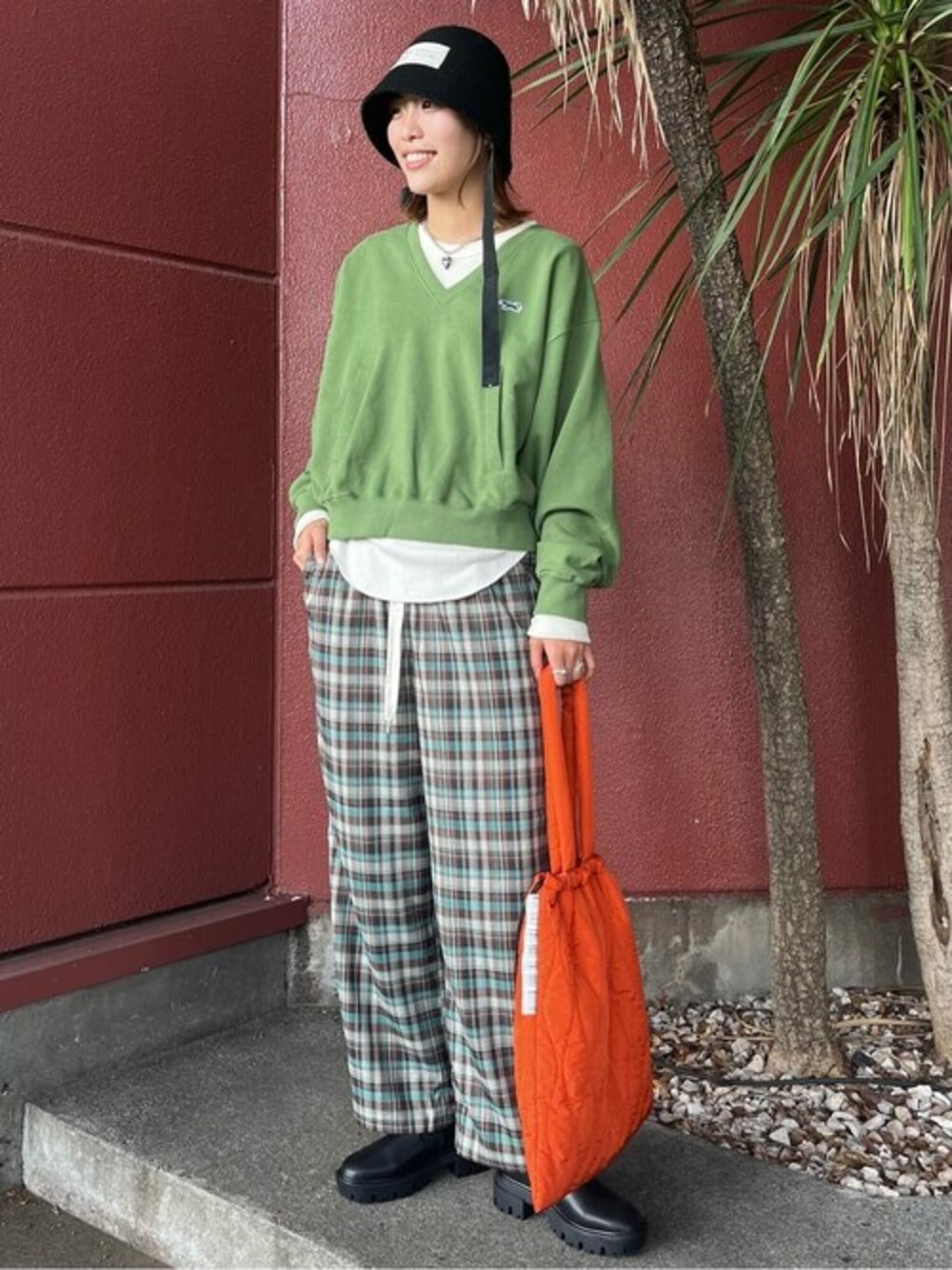 オレンジ系のトートバッグを着用したレディースの冬コーディネートの1枚目の写真