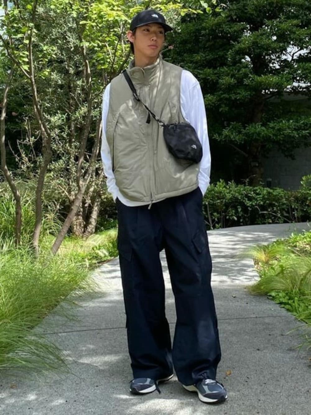 グリーン系のベスト、ブラック系のカーゴパンツを着用したメンズの冬コーディネートの1枚目の写真