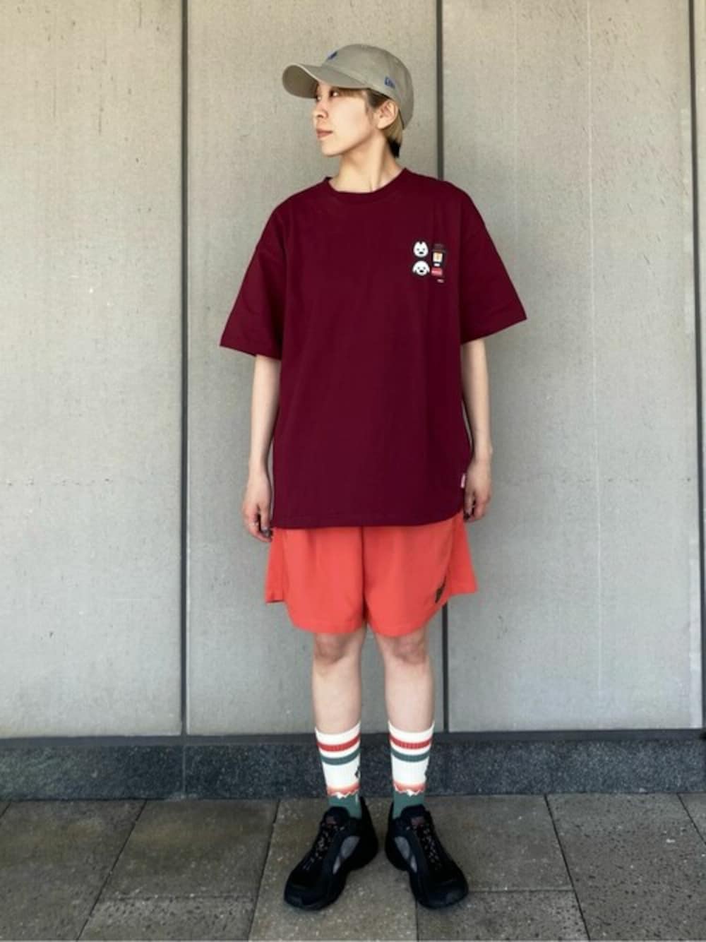 オレンジ系のその他パンツ、レッド系のTシャツ/カットソー、ベージュ系のキャップを着用したレディースの夏コーディネートの1枚目の写真