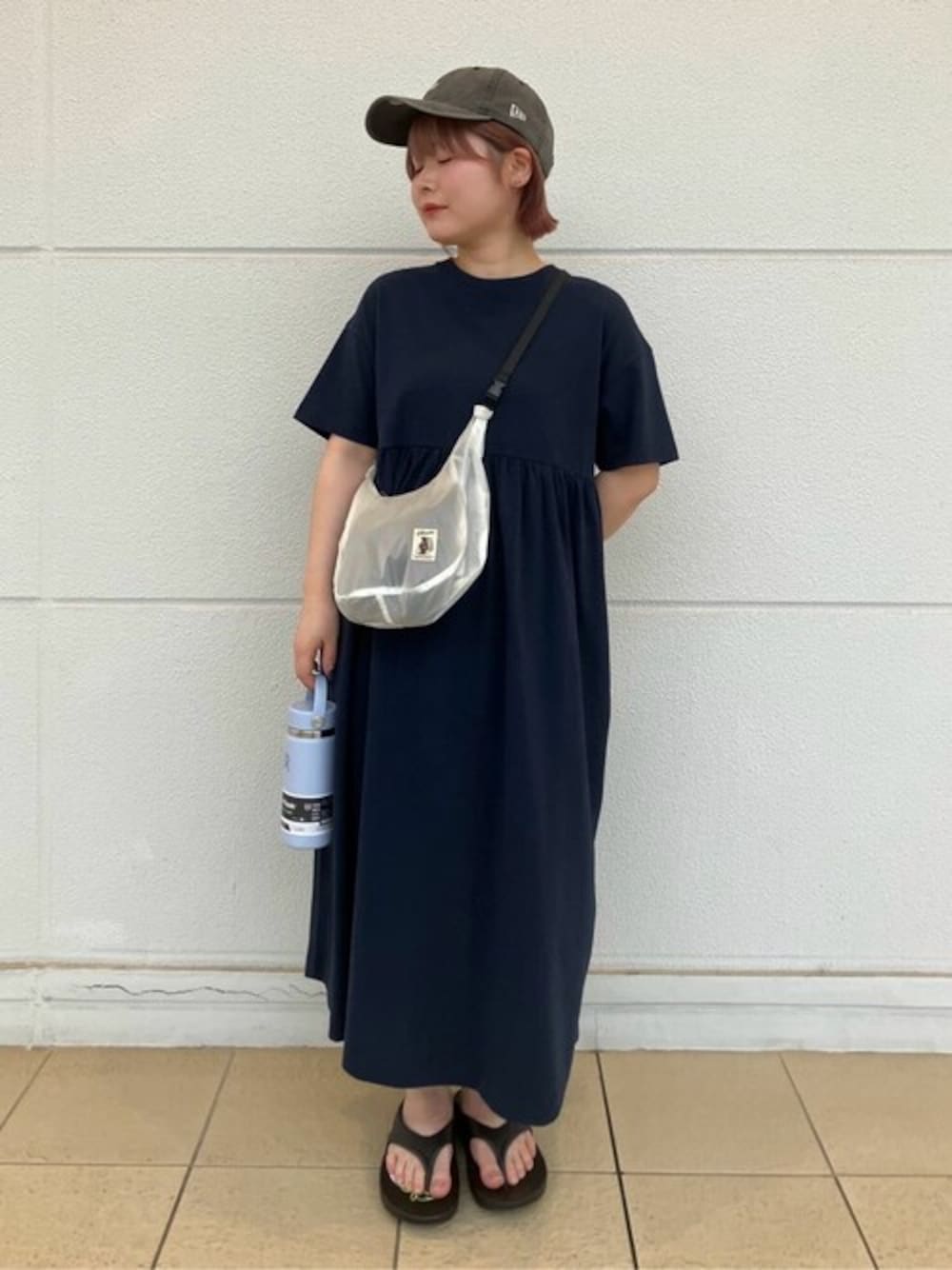 ブルー系のワンピース、ブラック系のサンダル、ブラック系のキャップを着用したレディースの夏コーディネートの1枚目の写真