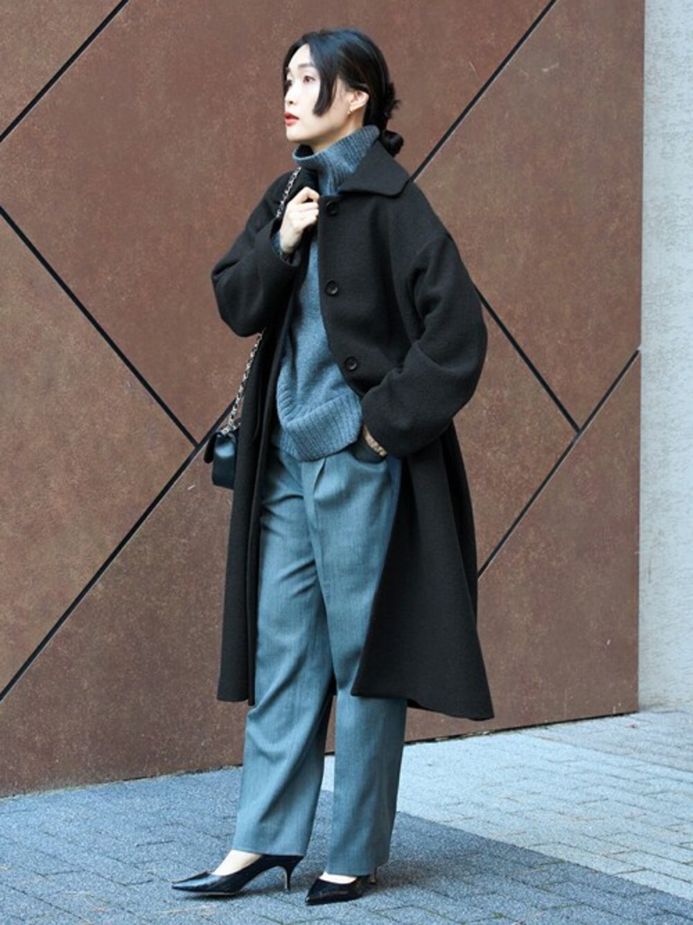 ブラック系のその他アウター、グレー系のニット/セーター、ブラック系のショルダーバッグを着用したレディースの冬コーディネートの1枚目の写真