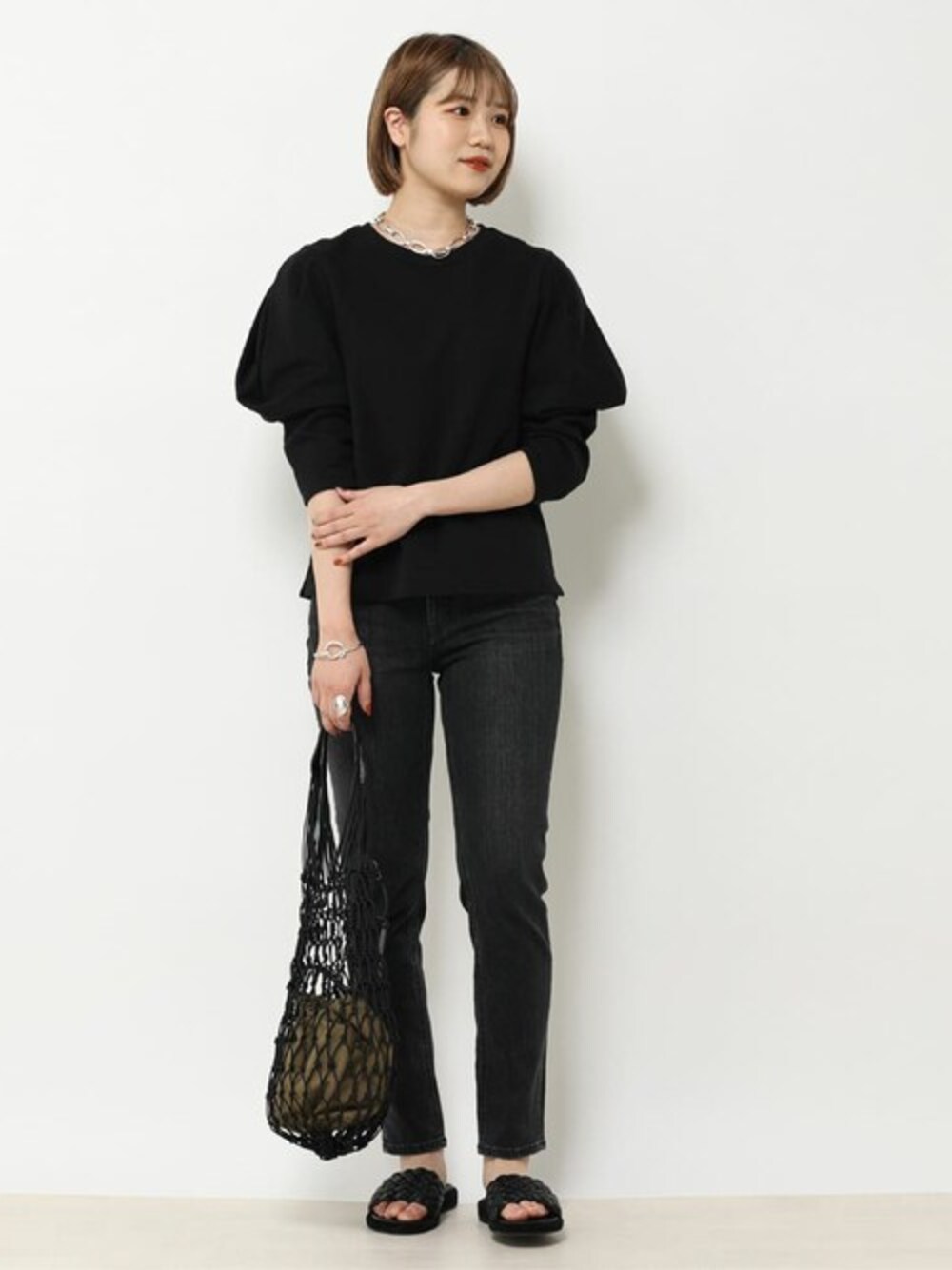 ブラック系のTシャツ/カットソー、ブラック系のショルダーバッグ、シルバー系のリングを着用したレディースの冬コーディネートの1枚目の写真