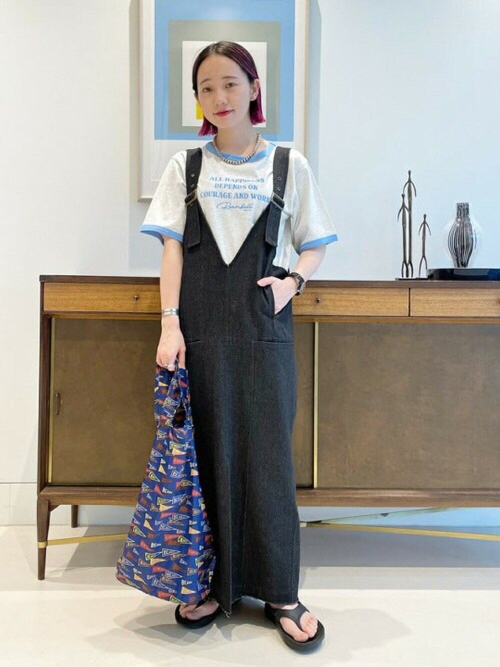 ブラック系のワンピース、ブルー系のTシャツ/カットソー、ブルー系のトートバッグを着用したレディースの春コーディネートの1枚目の写真