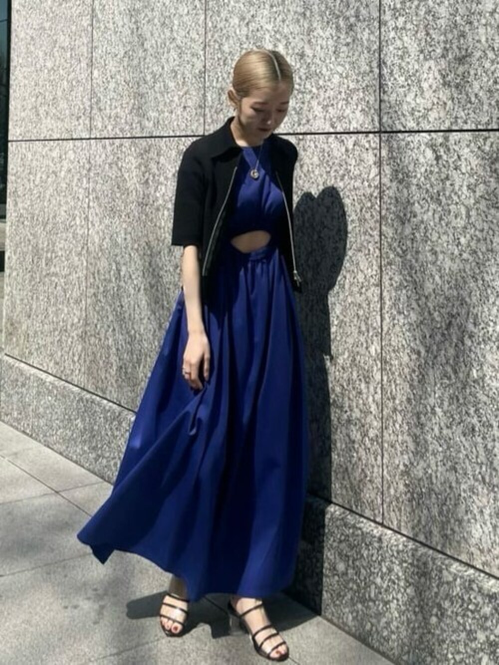 ブラック系のニット/セーター、ブラック系のサンダルを着用したレディースの春コーディネートの1枚目の写真