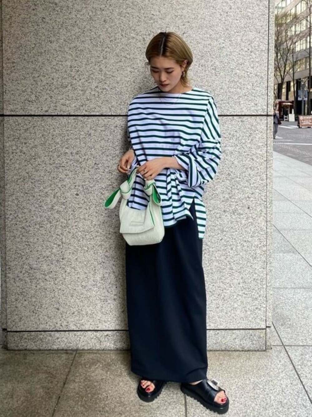 グリーン系のTシャツ/カットソー、ブラック系のサンダルを着用したレディースの春コーディネートの1枚目の写真