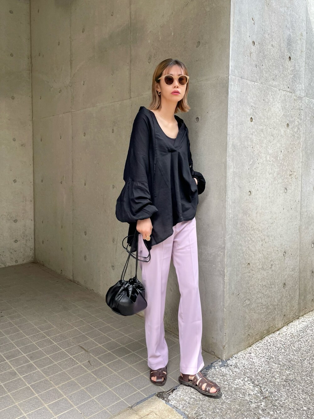 ブラック系のシャツ/ブラウス、ホワイト系のショルダーバッグ、パープル系のスラックスを着用したレディースの春コーディネートの1枚目の写真