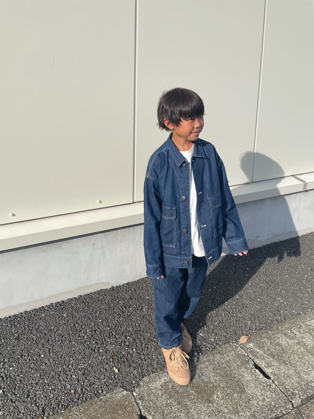 ホワイト系のデニムジャケット、ブルー系のその他パンツ、ベージュ系のシューズを着用したキッズの秋コーディネートの1枚目の写真