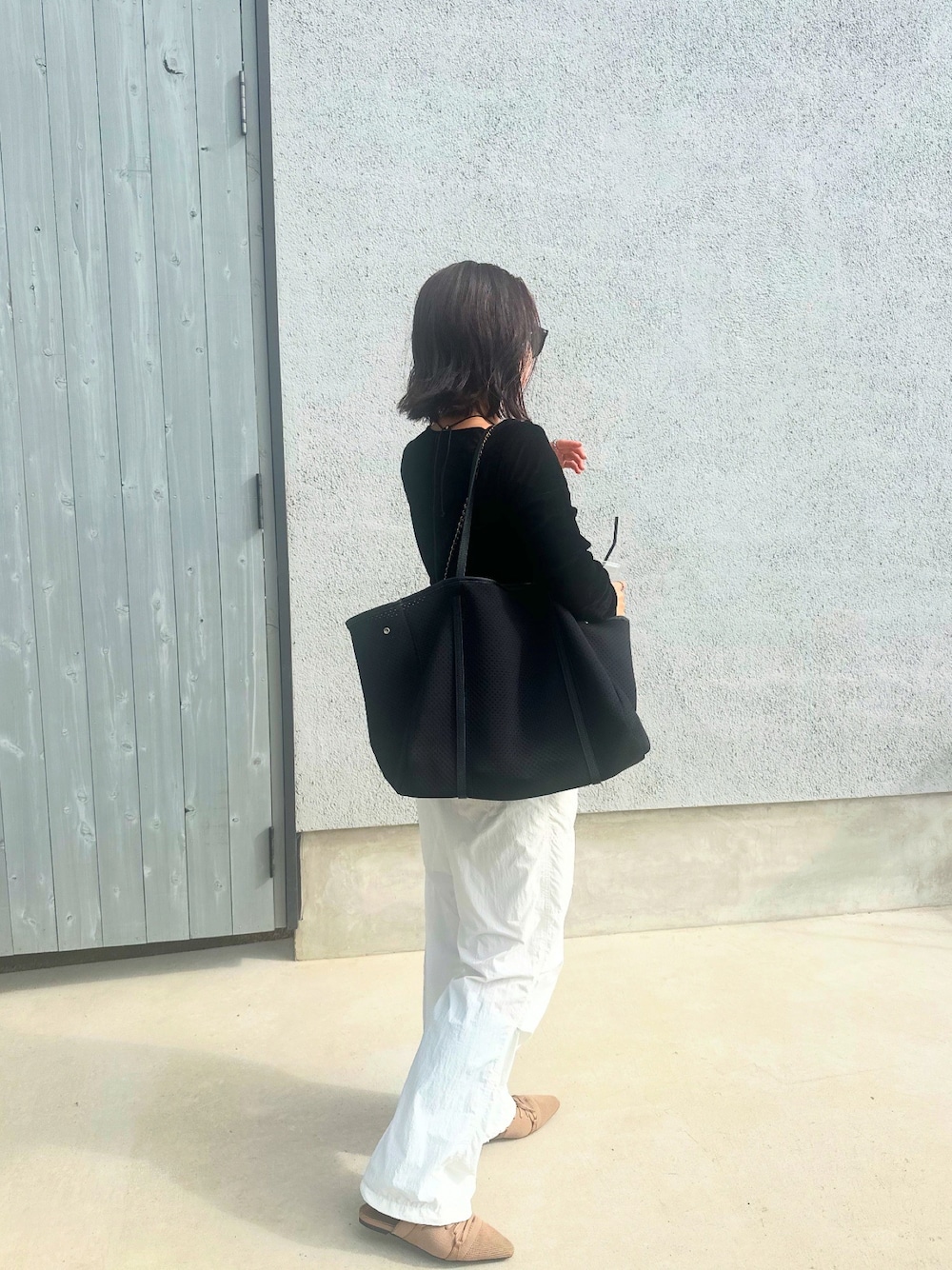 ブラック系のトートバッグを着用したレディースの秋コーディネートの1枚目の写真