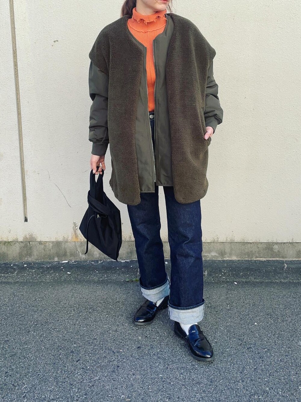 グリーン系のノーカラージャケットを着用したレディースの秋コーディネートの1枚目の写真