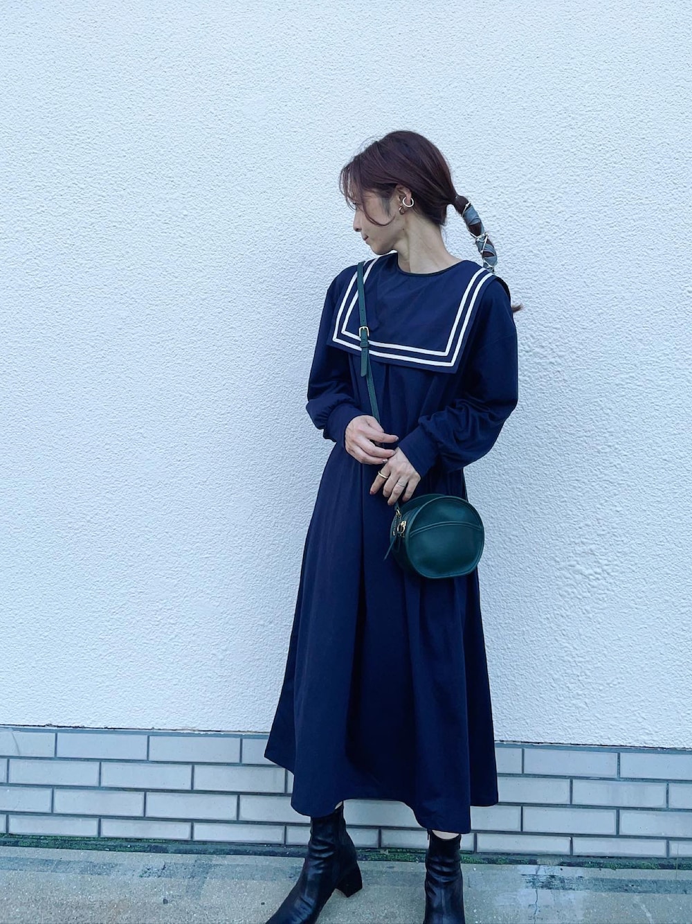 ブルー系のワンピース、グリーン系のショルダーバッグ、ブラック系のブーツを着用したレディースの秋コーディネートの1枚目の写真