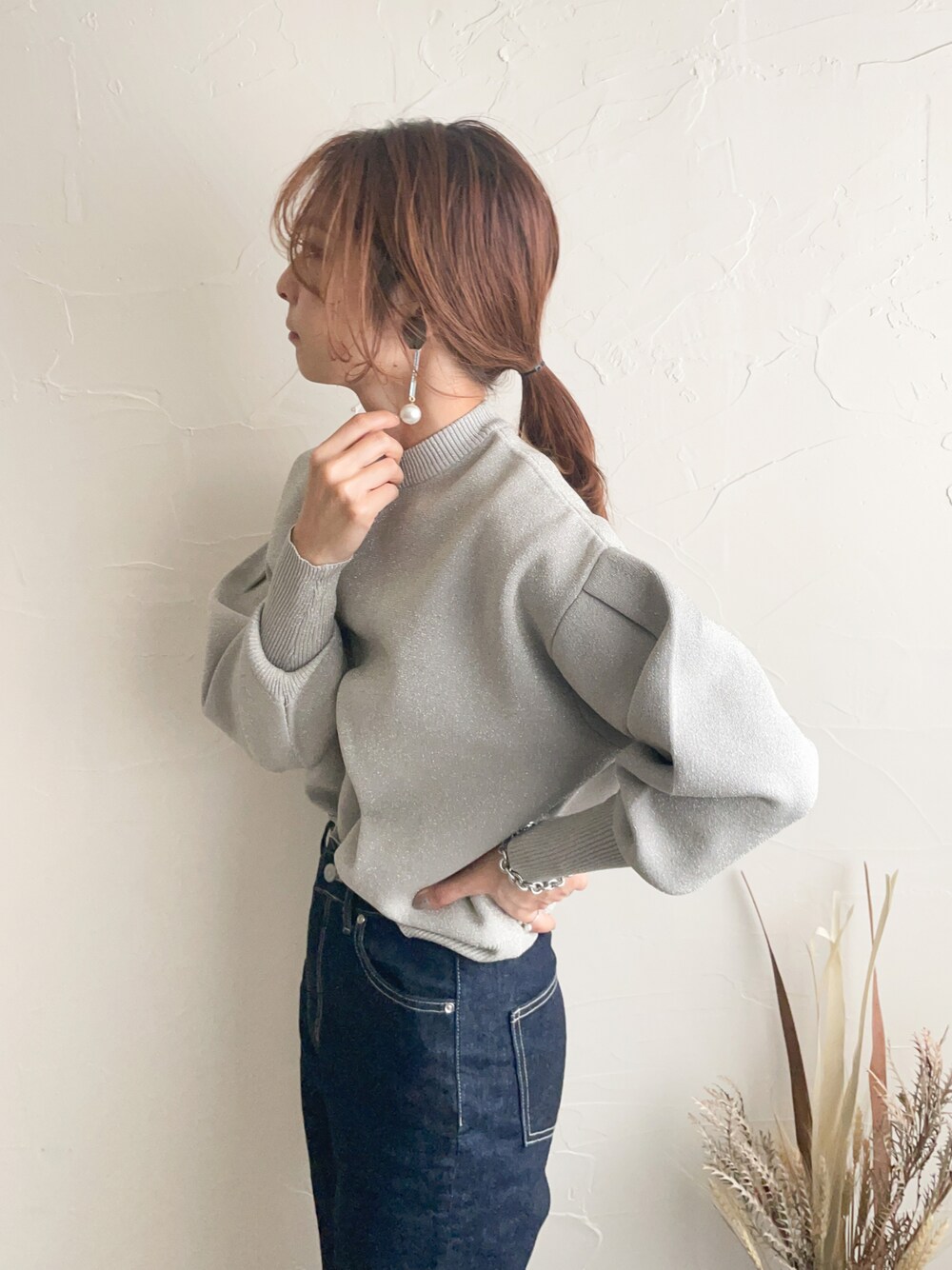 ベージュ系のニット/セーター、ブルー系のデニムパンツを着用したレディースの秋コーディネートの1枚目の写真