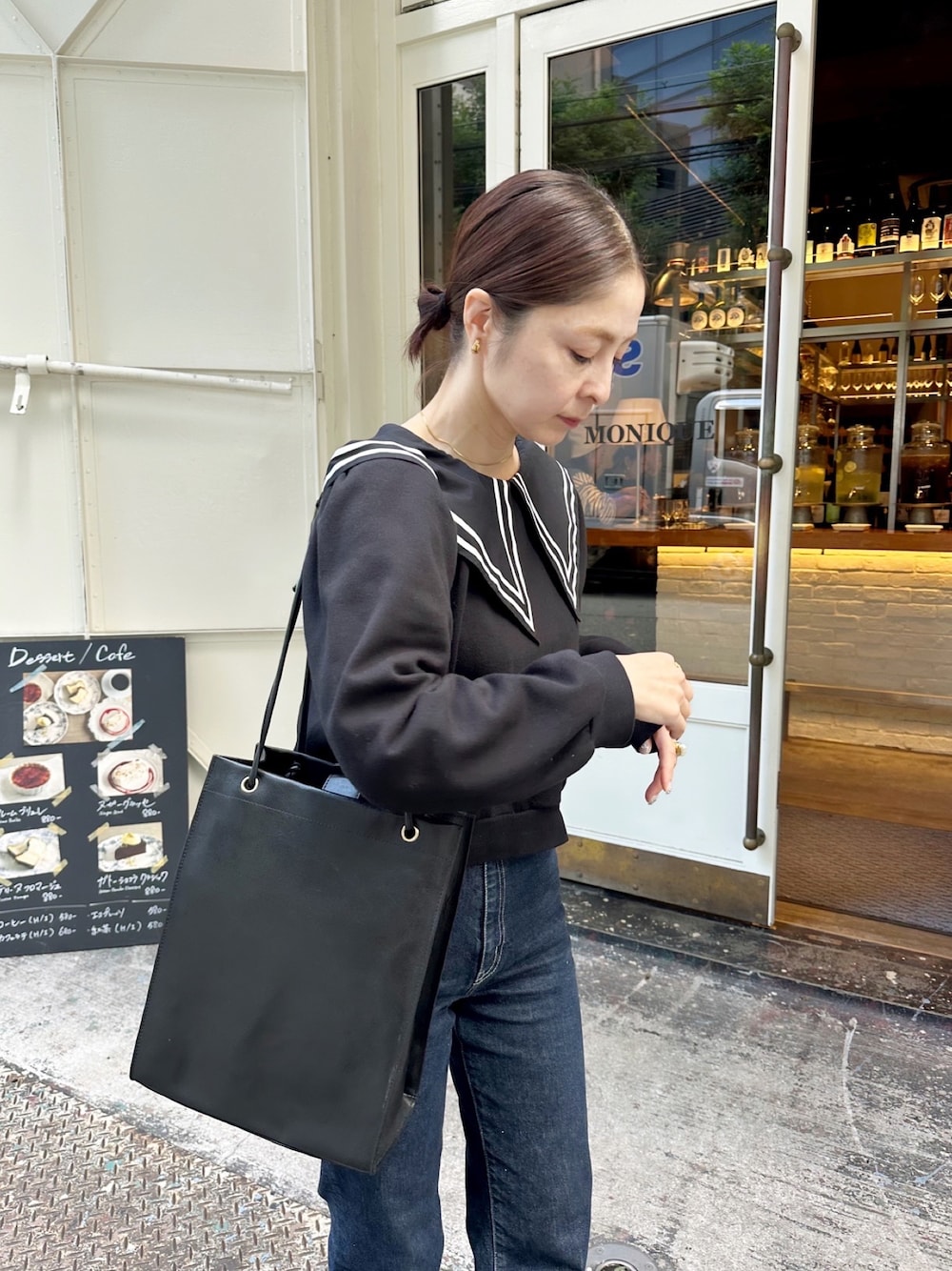 ブラック系のバッグを着用したレディースの秋コーディネートの1枚目の写真