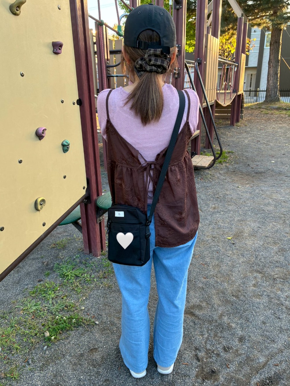 ピンク系のTシャツ/カットソー、ブラウン系のキャミソール、ブルー系のデニムパンツを着用したレディースの秋コーディネートの1枚目の写真