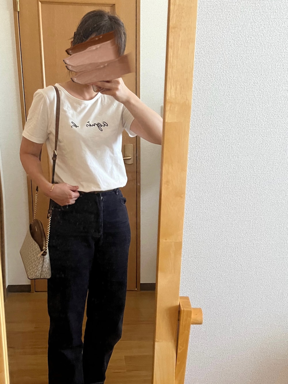 ホワイト系のTシャツ/カットソー、ブルー系のデニムパンツ、ホワイト系のショルダーバッグを着用したレディースの秋コーディネートの1枚目の写真