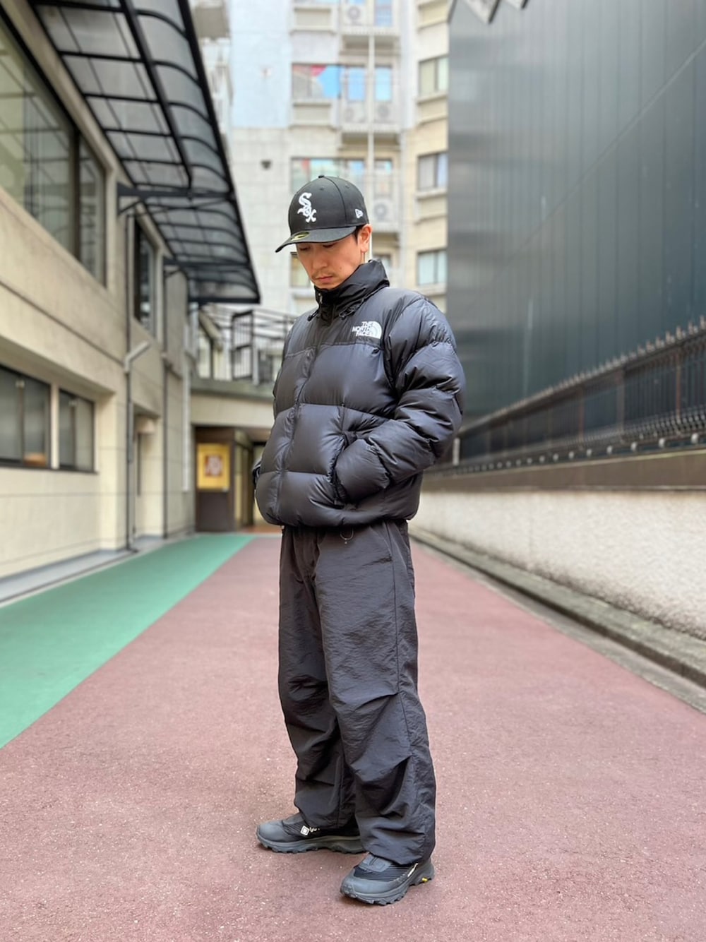 ブラック系のダウンジャケット/コート、ブラック系のその他パンツ、ブラック系のキャップを着用したメンズの秋コーディネートの1枚目の写真