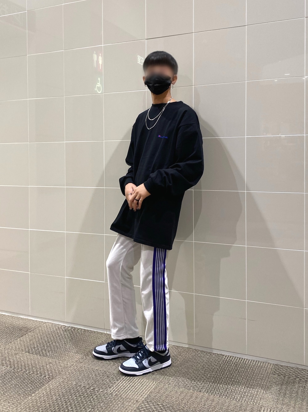 ブルー系のスニーカー、ホワイト系のパンツ、ブラック系のTシャツ/カットソーを着用したメンズの秋コーディネートの1枚目の写真