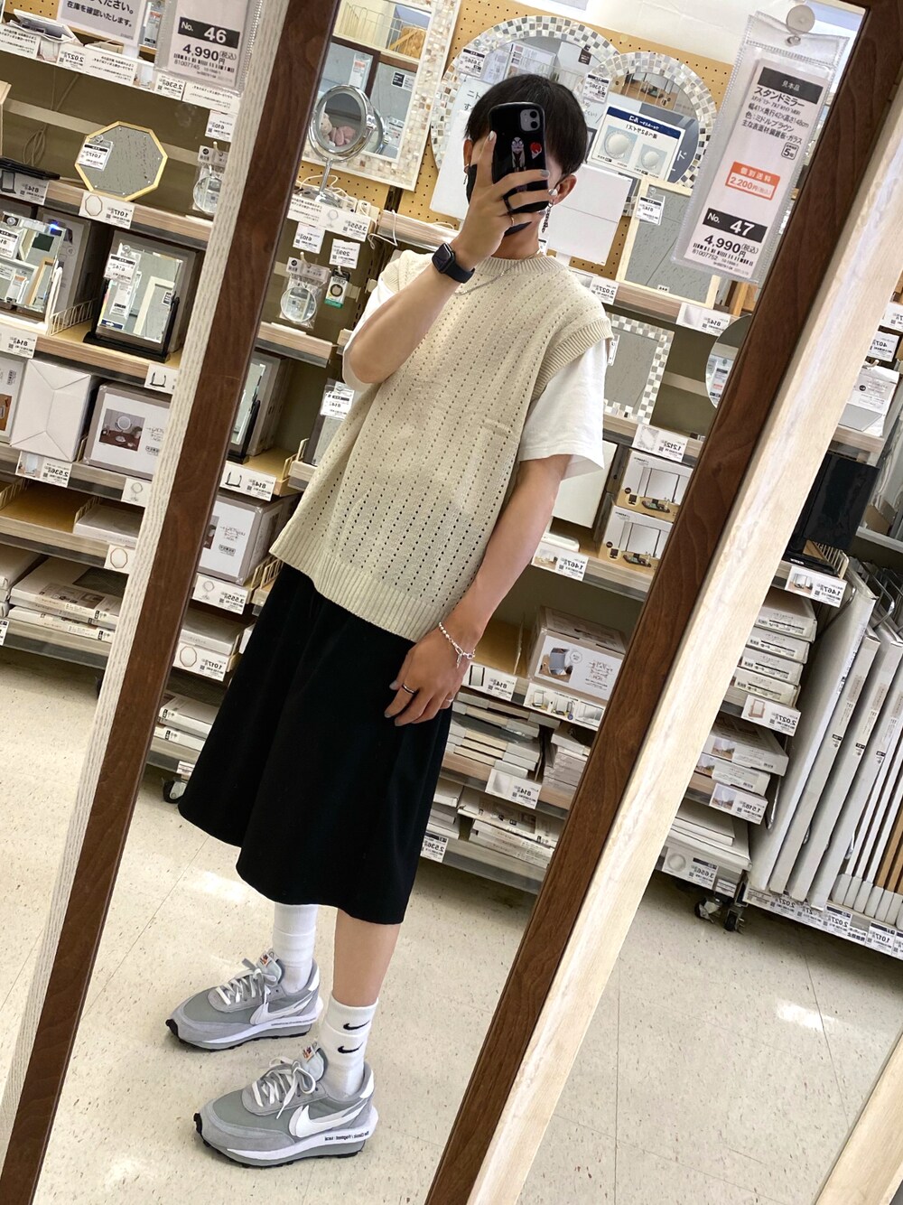 グレー系のスニーカー、ブラック系のパンツ、ベージュ系のベストを着用したメンズの秋コーディネートの1枚目の写真