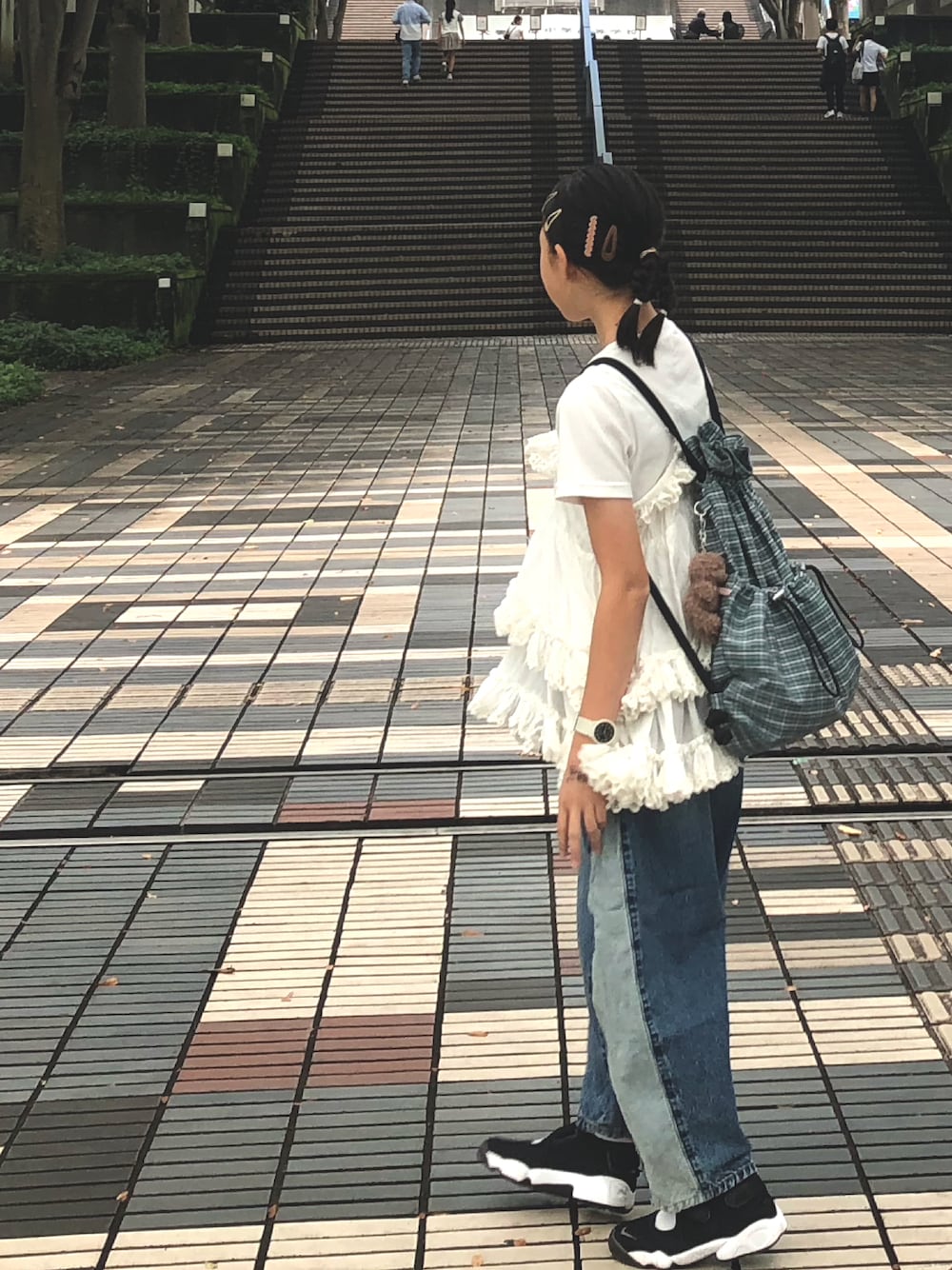 ホワイト系のワンピース、ブルー系のデニムパンツ、グリーン系のバックパック/リュックを着用したキッズの秋コーディネートの1枚目の写真