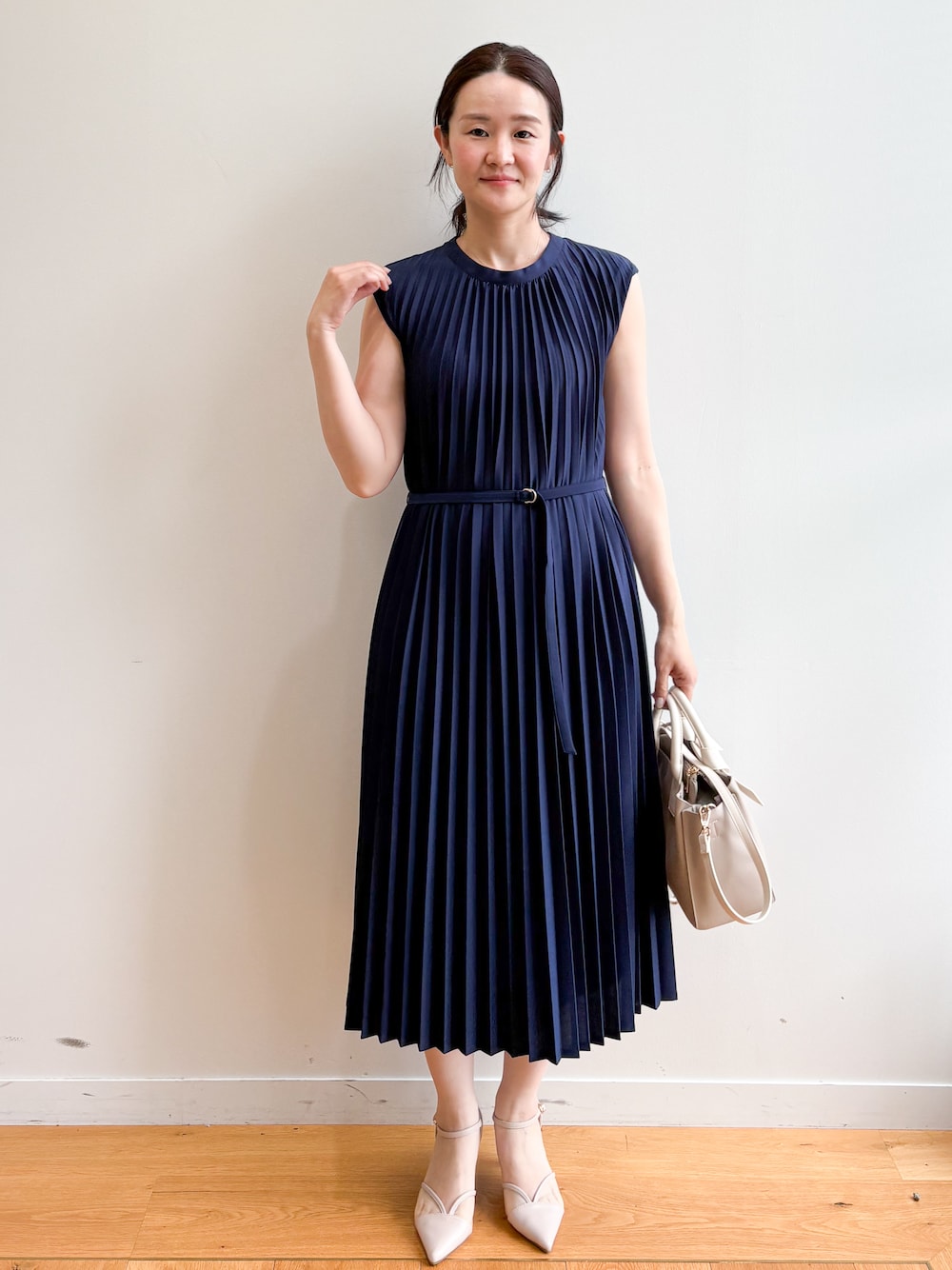 ベージュ系のトートバッグ、ベージュ系のパンプス、ブルー系のワンピースを着用したレディースの夏コーディネートの1枚目の写真