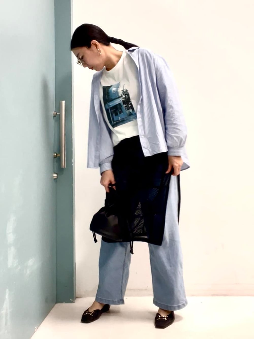ブルー系のシャツ/ブラウス、ホワイト系のTシャツ/カットソー、ブラック系のスカートを着用したレディースの春コーディネートの1枚目の写真