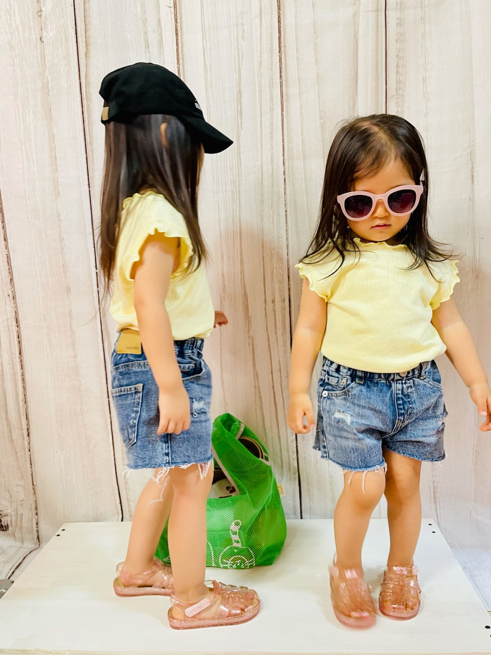 「姉妹コーデ、リンクコーデ、キャップ、サングラス、フレンチスリーブ、Tシャツ、デニム、ショートパンツ、クラッシュデニム、ダメージデニムパンツ、タックイン、サンダル、ラメサンダル、メッシュバッグ、甘辛mix」｜「devirockのロゴ入りローキャップ（キャップ、ブラック系）」を使った、moe♡mokaさん（キッズ・90cm）の夏コーディネートの1枚目の写真
