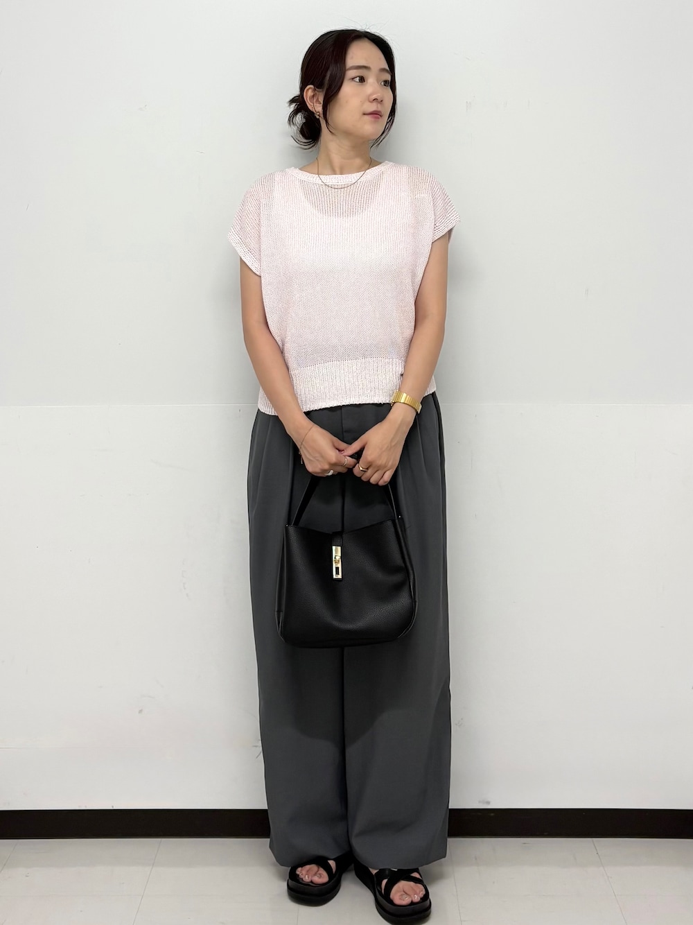 ピンク系のニット/セーター、グレー系のその他パンツ、ブラック系のトートバッグを着用したレディースの夏コーディネートの1枚目の写真