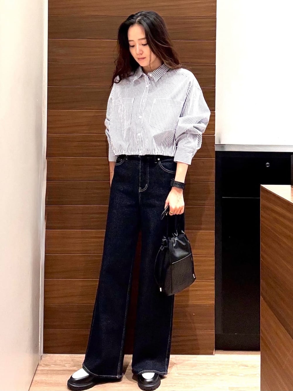 ブルー系のシャツ/ブラウス、ブルー系のデニムパンツ、ブラック系のショルダーバッグを着用したレディースの秋コーディネートの1枚目の写真