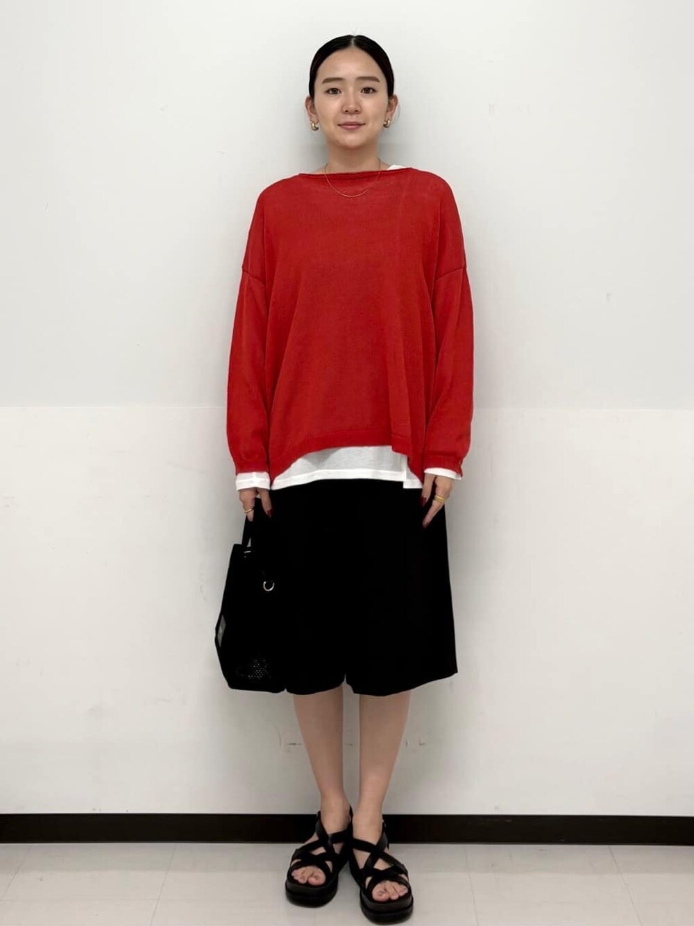 ブラック系のトートバッグ、ホワイト系のTシャツ/カットソー、ブラック系のサンダルを着用したレディースの春コーディネートの1枚目の写真