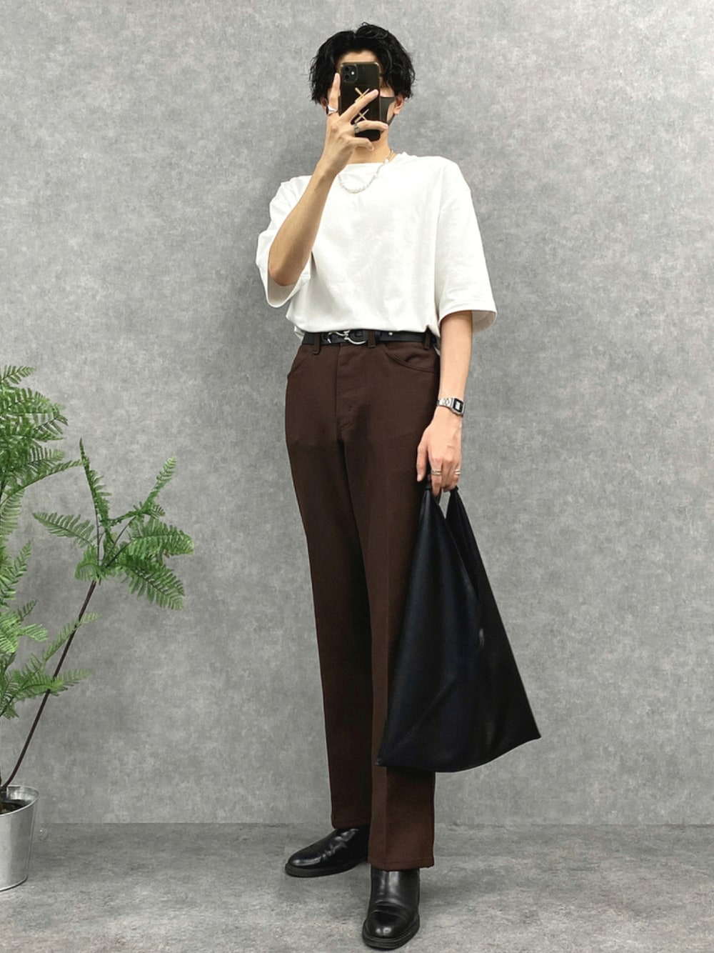 ホワイト系のTシャツ/カットソー、ブラウン系のスラックス、ブラック系のトートバッグを着用したメンズの秋コーディネートの1枚目の写真