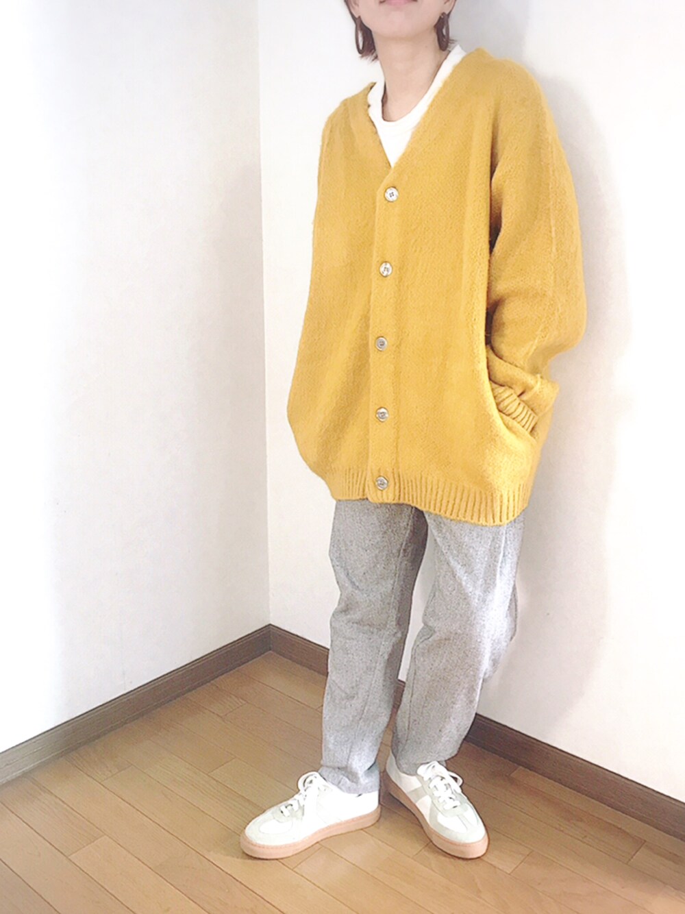 イエロー系のカーディガン/ボレロ、ベージュ系のその他パンツ、ホワイト系のスニーカーを着用したレディースの冬コーディネートの1枚目の写真