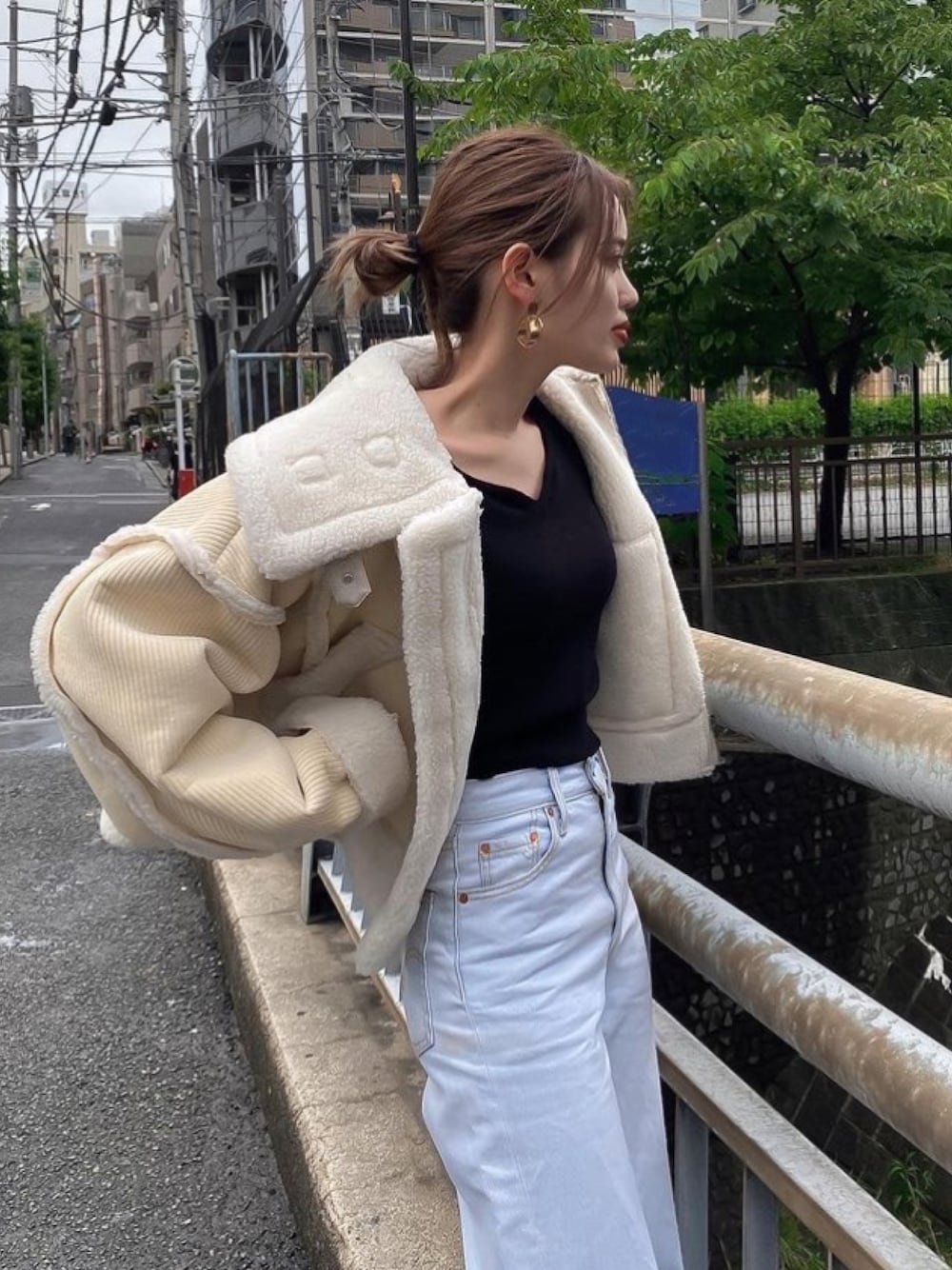 ホワイト系のムートンコートを着用したレディースの夏コーディネートの1枚目の写真