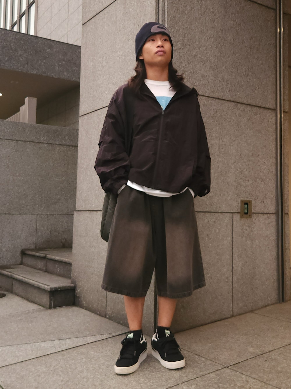 ブラック系のブルゾン、ブラック系のデニムパンツ、グリーン系のショルダーバッグを着用したメンズの秋コーディネートの1枚目の写真