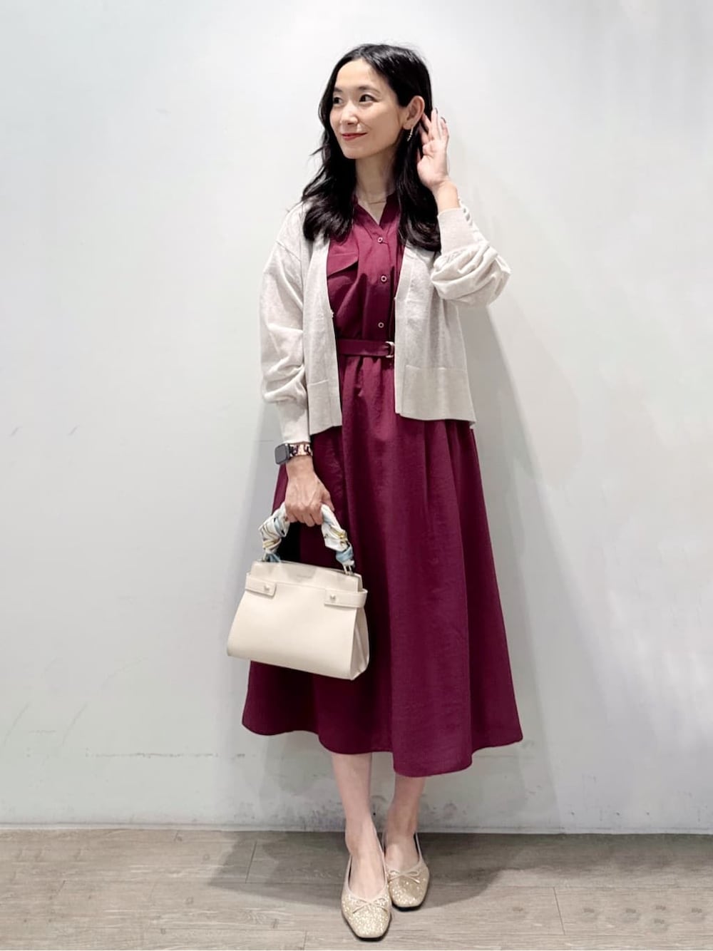 ベージュ系のカーディガン/ボレロ、レッド系のワンピース、ホワイト系のショルダーバッグを着用したレディースの秋コーディネートの1枚目の写真