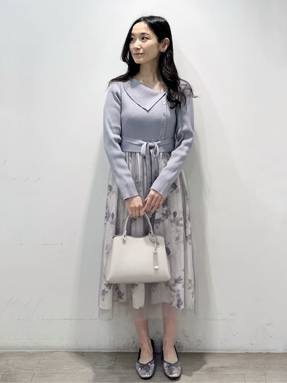 ブルー系のワンピース、ベージュ系のショルダーバッグ、シルバー系のパンプスを着用したレディースの春コーディネートの1枚目の写真