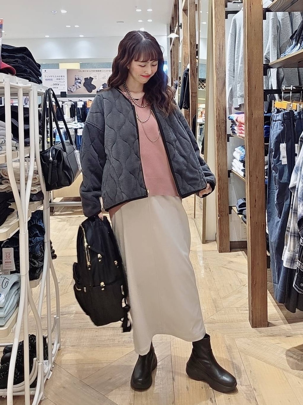 グレー系のブルゾン、ピンク系のスウェット、グレー系のスカートを着用したレディースの秋コーディネートの1枚目の写真