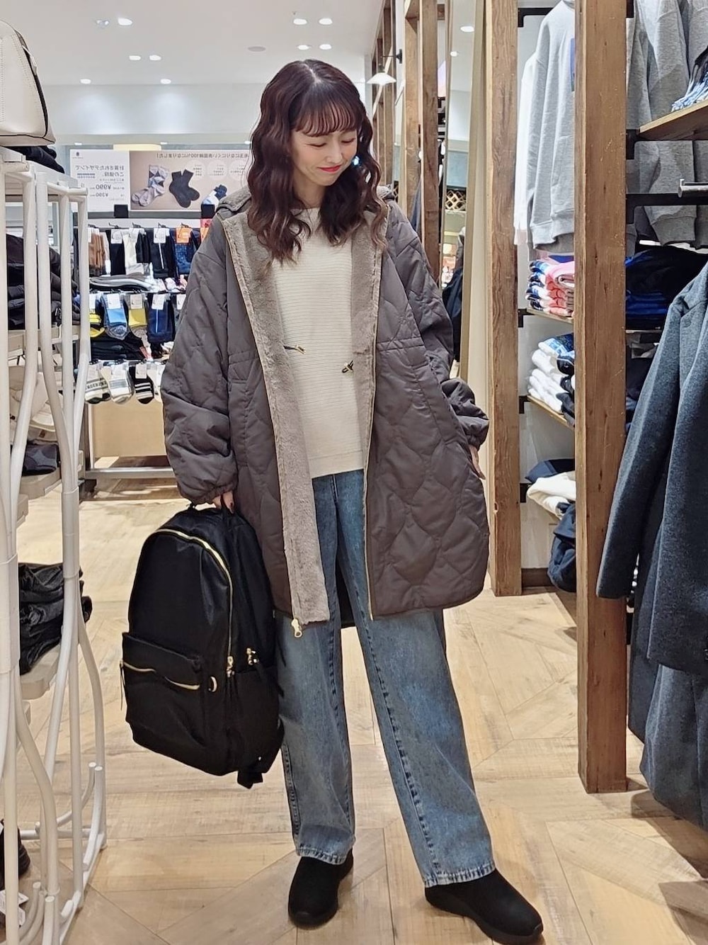 ブルー系のデニムパンツ、ブラウン系のブルゾン、ブラック系のバックパック/リュックを着用したレディースの秋コーディネートの1枚目の写真