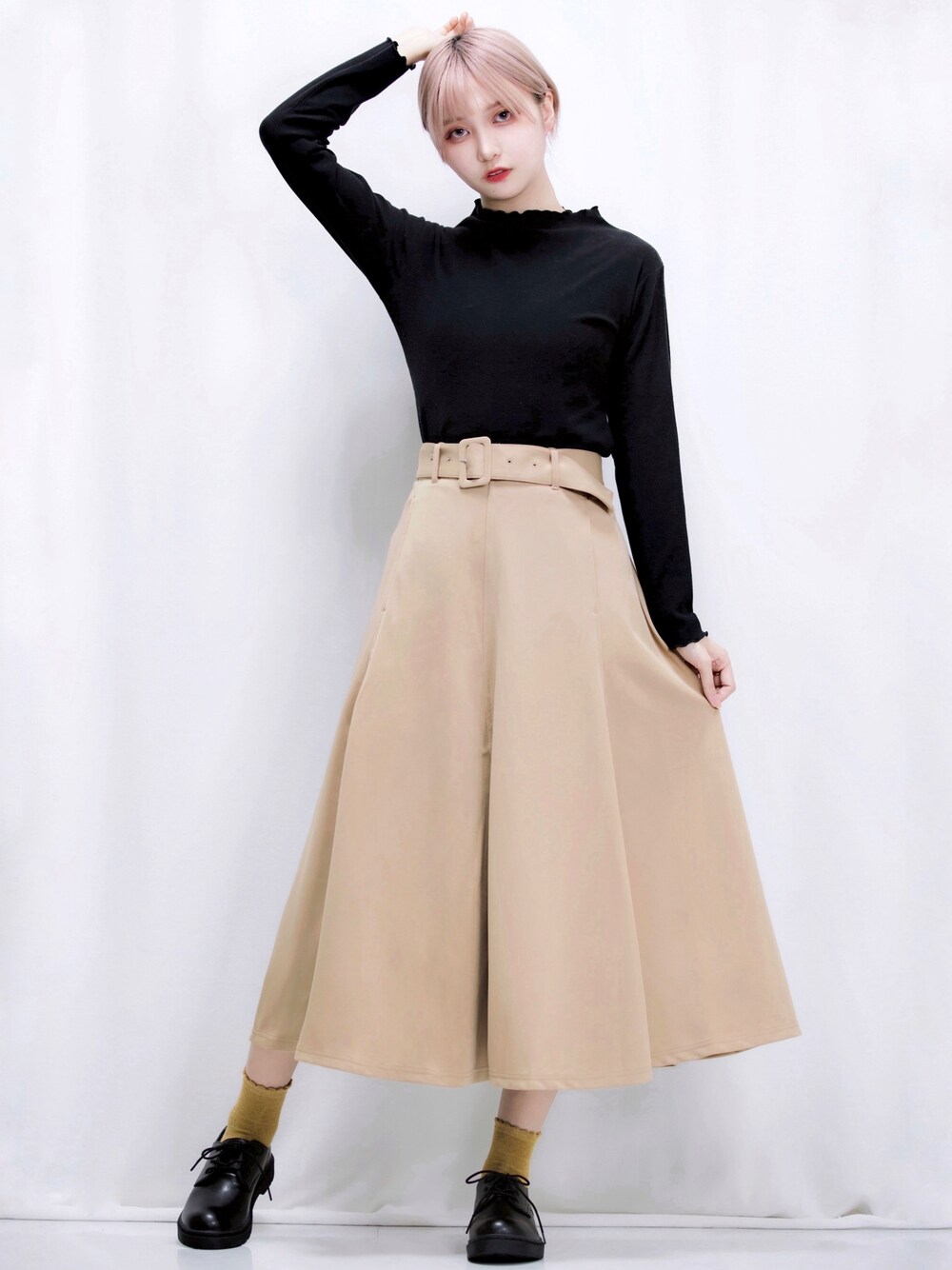 ベージュ系のスカート、ブラック系のTシャツ/カットソー、ブラック系のシューズを着用したレディースの冬コーディネートの1枚目の写真