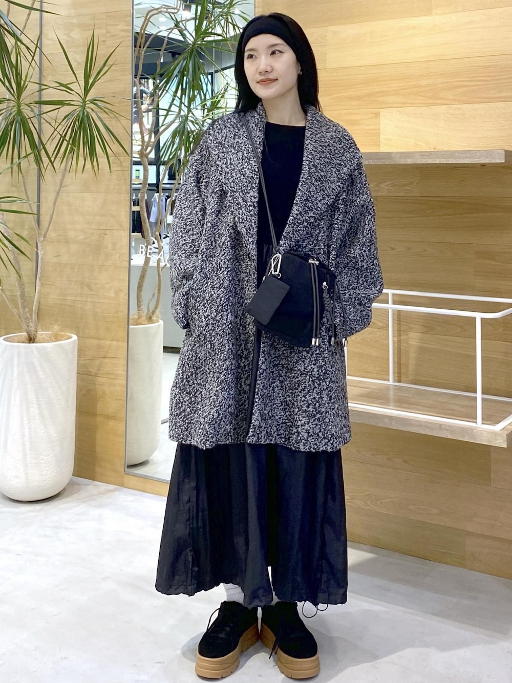 ブラック系のショルダーバッグ、ブラック系のワンピース、ブラック系のチェスターコートを着用したレディースの秋コーディネートの1枚目の写真