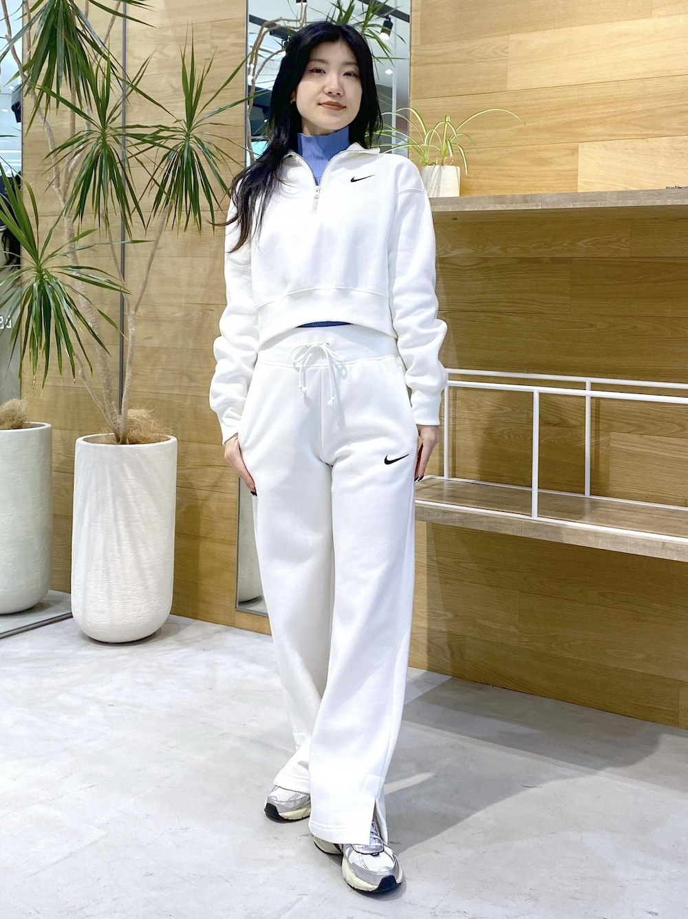 ホワイト系のスニーカー、ブルー系のニット/セーター、ブラック系のその他パンツを着用したレディースの秋コーディネートの1枚目の写真